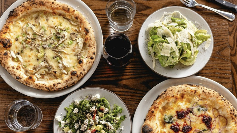 Pizza, salad, and drinks on table