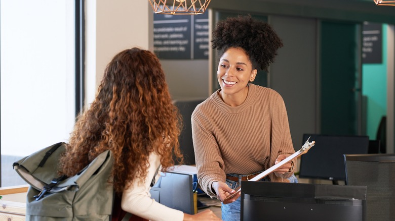 traveler talks to hotel clerk