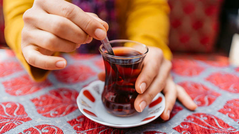 Traveler stirring glass of Turkish tea