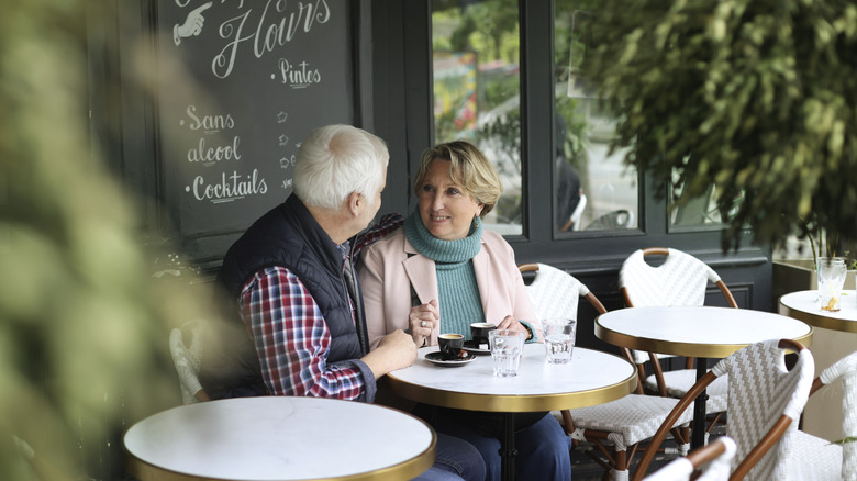 Couple sitting outside French cafe