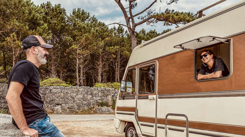 Man smiling at woman inside a campervan