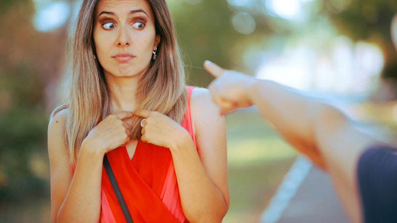 Hand aggressively pointing at woman