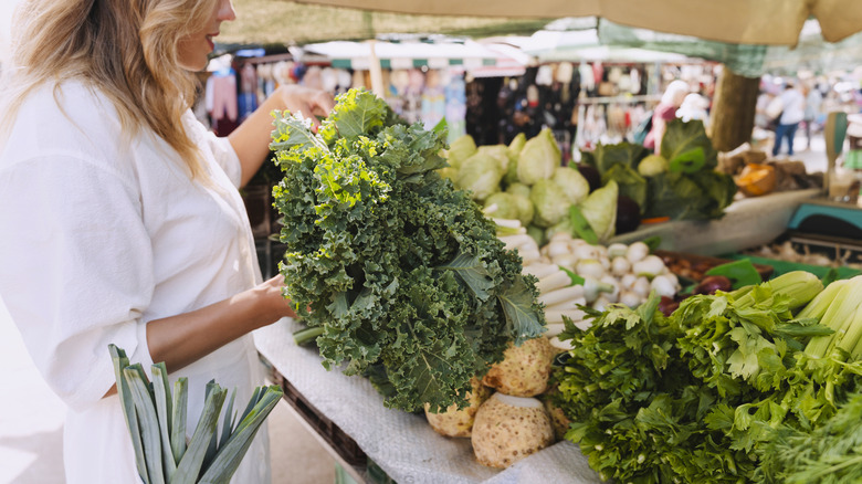 Shopper picking vegetables at farmer's market