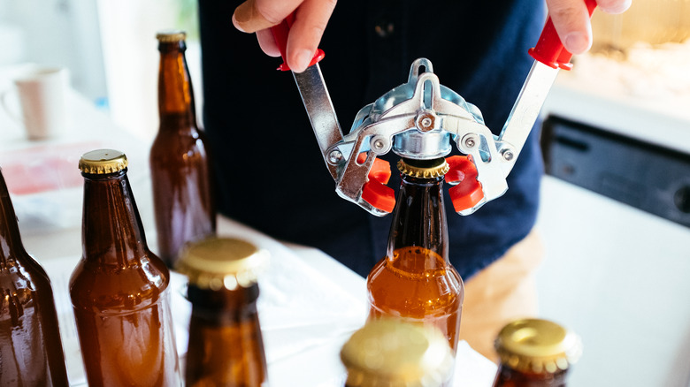 An amateur brewer bottles his own beer at home