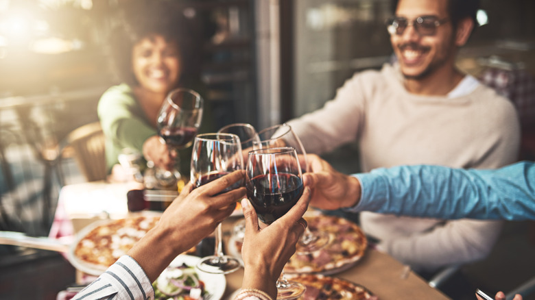 A group toasts with wine glasses.