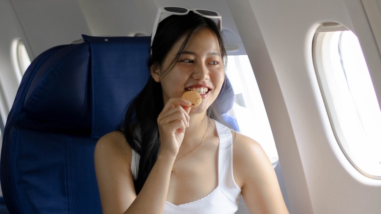 Woman holding food on plane