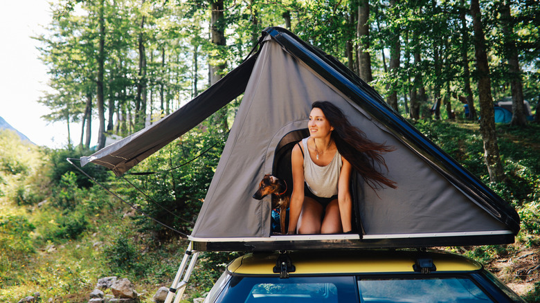 Traveler coming out of rooftop tent