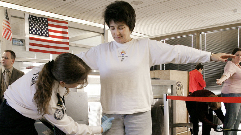 Woman getting a pt-down by TSA officer