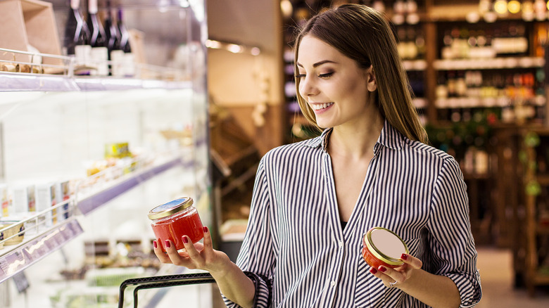 smiling woman holding caviar jars