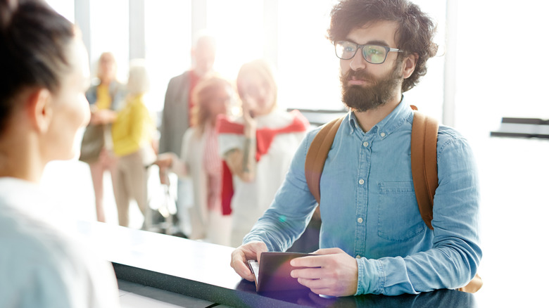 Man with beard and glasses checks into airport