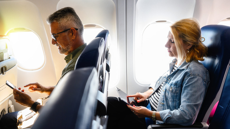 Passengers seated on a plane.