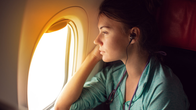 woman looking out plane window