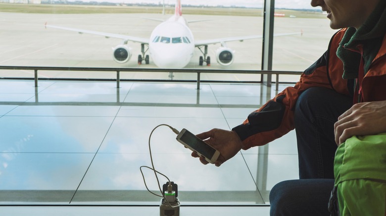 Passenger charging phone in airport