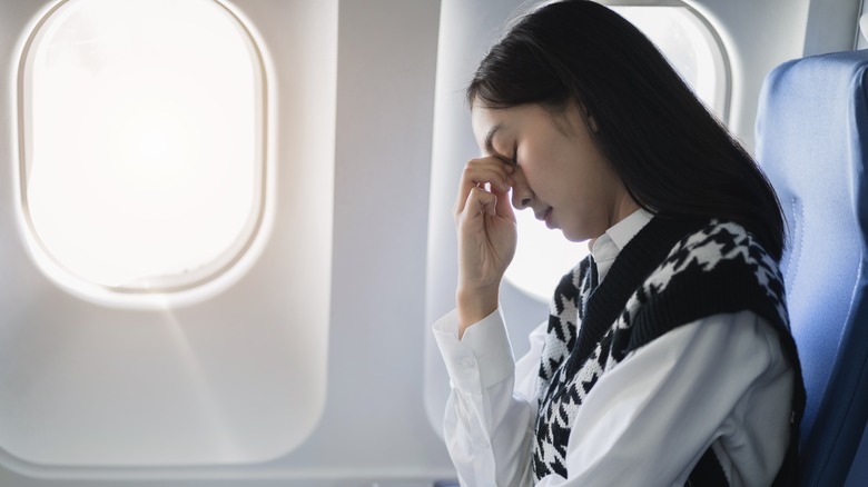 woman with headache on plane