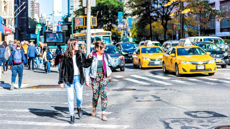 Two women cross a New York street during the don't walk signal.