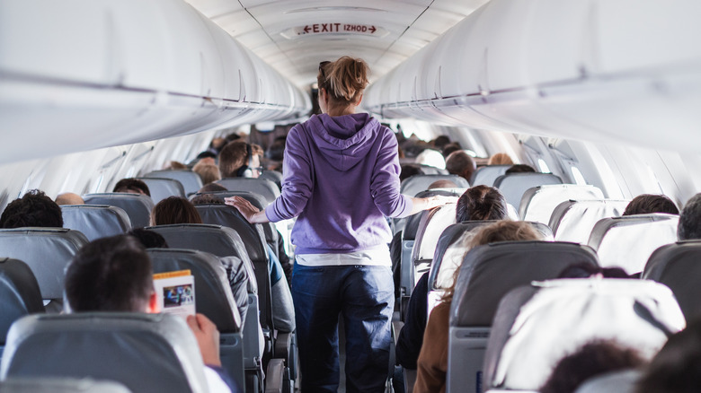 Passenger walking down an airplane aisle