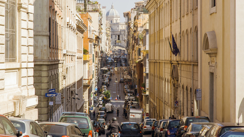 Traffic lined a narrow old street in an Italian city