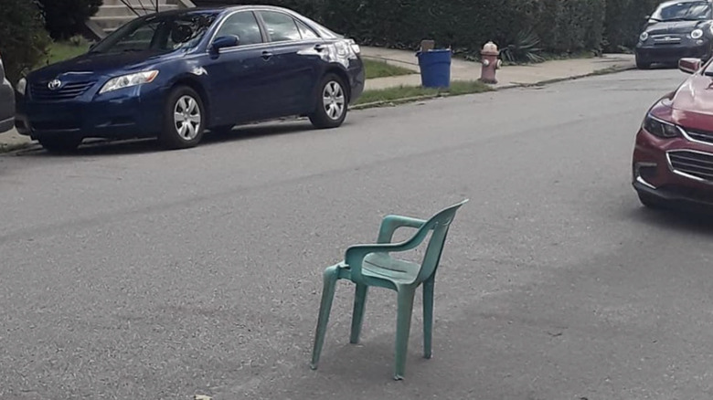 A green chair stands in the street