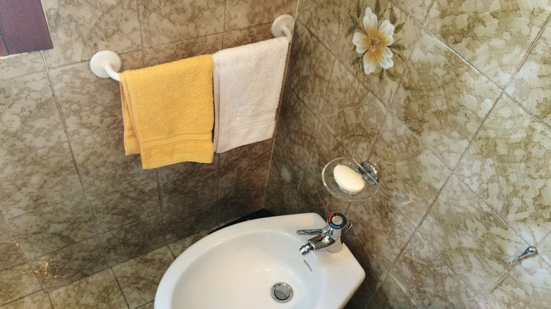Two towels next to a bidet