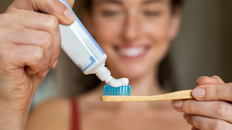 Woman squeezing toothpaste onto toothbrush