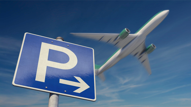 Blue and white parking sign under departing plane