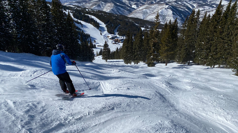 man skiing down moguls 
