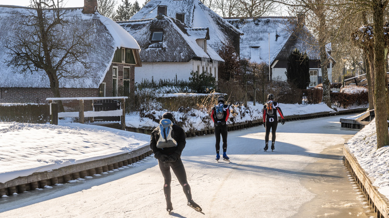 Ice skaters on frozen canal in Giethoorn