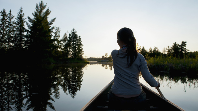 Woman canoeing over the smooth surface of Lake of the Woods