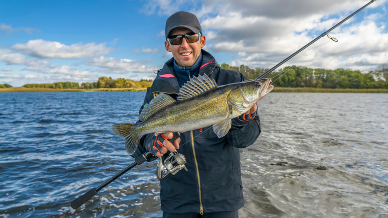 Man holding a trophy walley on a lake