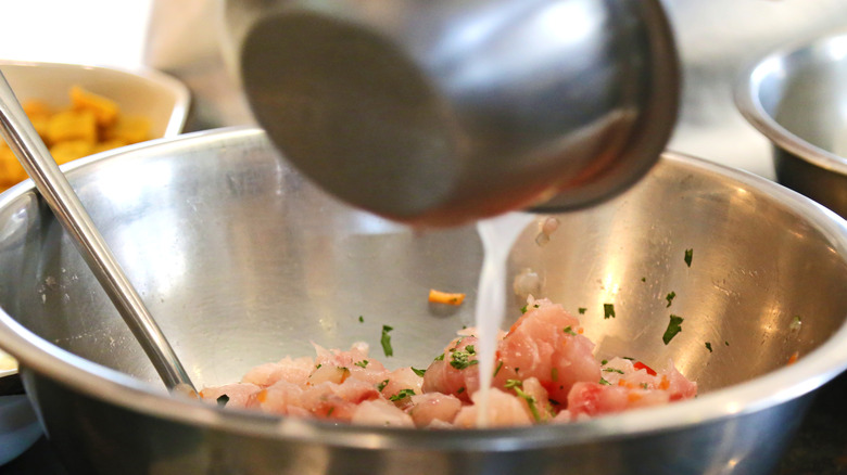 pouring leche de tigre into ceviche bowl