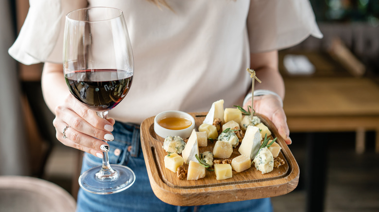 woman holding wine and charcuterie