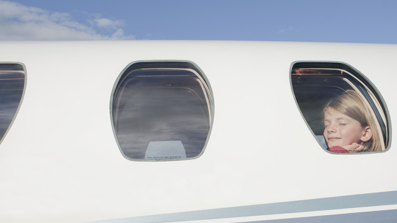 Girl looking through plane window