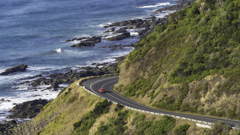 red car on coastal highway