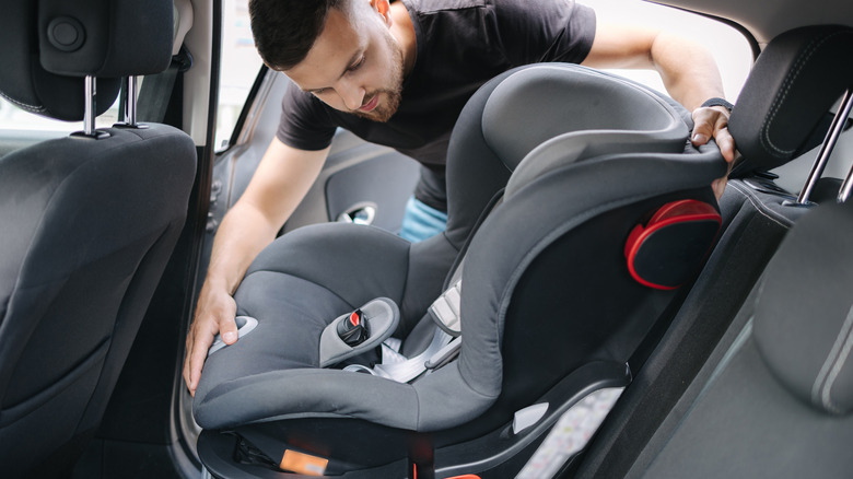 Man putting car seat in