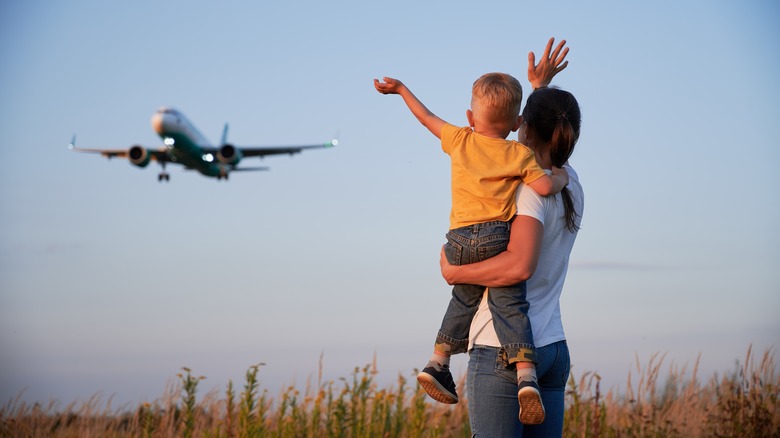 mother and child waving at plane