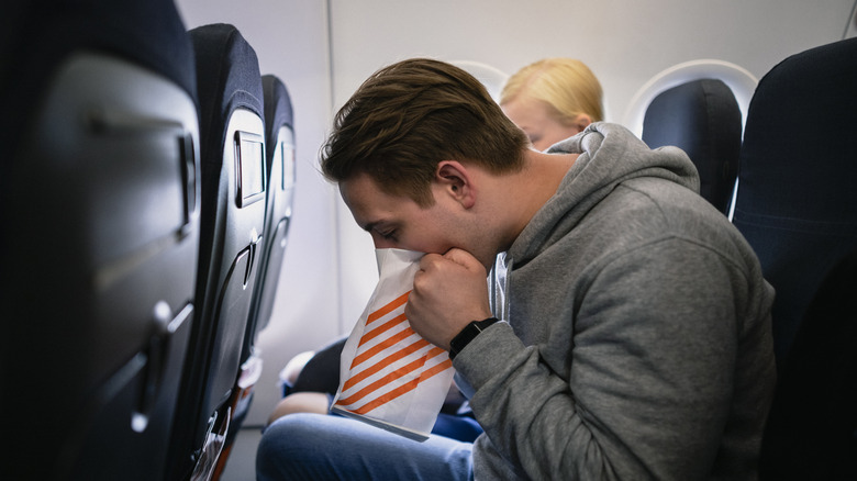 man using plane's sick bag