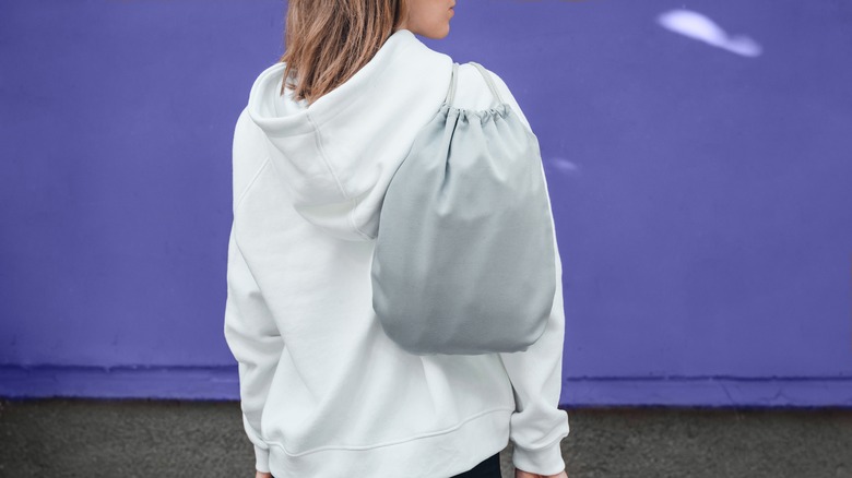 Woman carrying drawstring bag