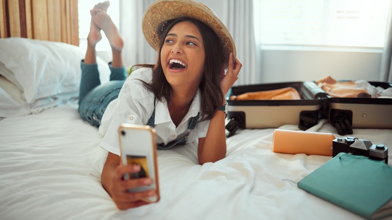 Smiling Airbnb guest laying on bed