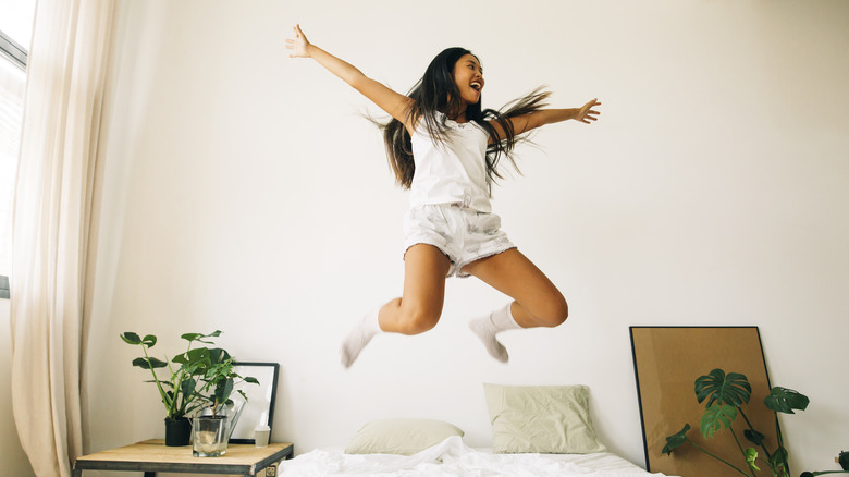 Young traveler jumping on the bed