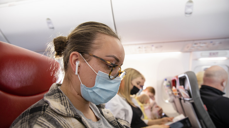 Woman wearing AirPods on plane