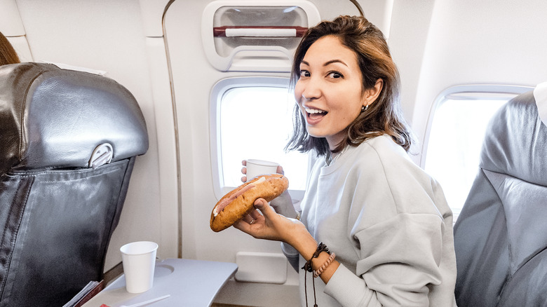 Woman eating sandwich on plane