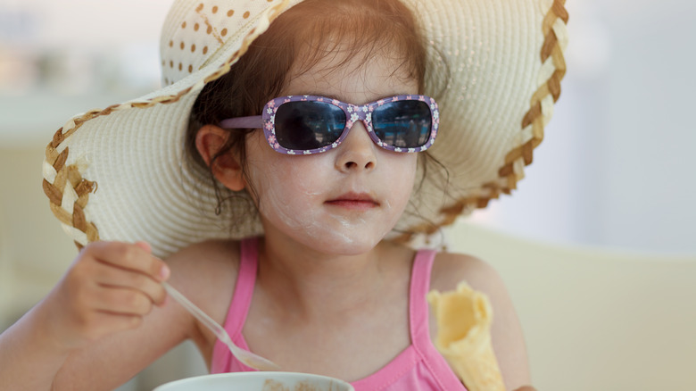 sun-protected child eating ice cream