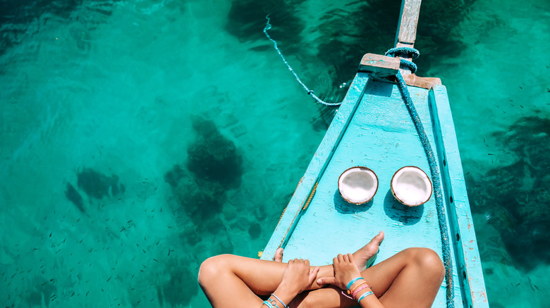 Person enjoying coconuts on a boat