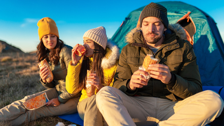 campers eating sandwiches tent