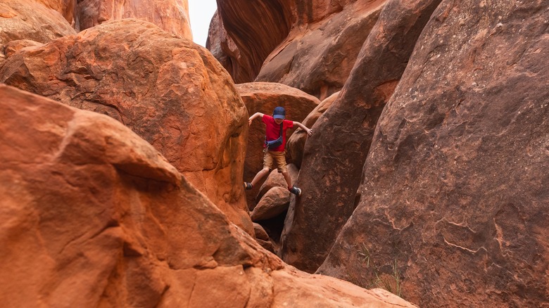 boy rock-scrambling in canyon