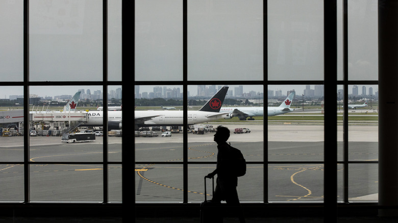 Traveler walks by Air Canada planes