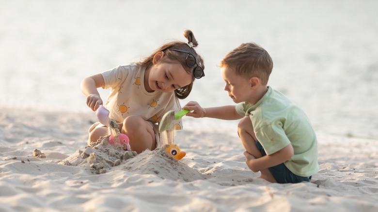 Children playing with sand at the beach