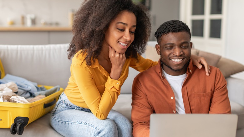 Couple using laptop before trip