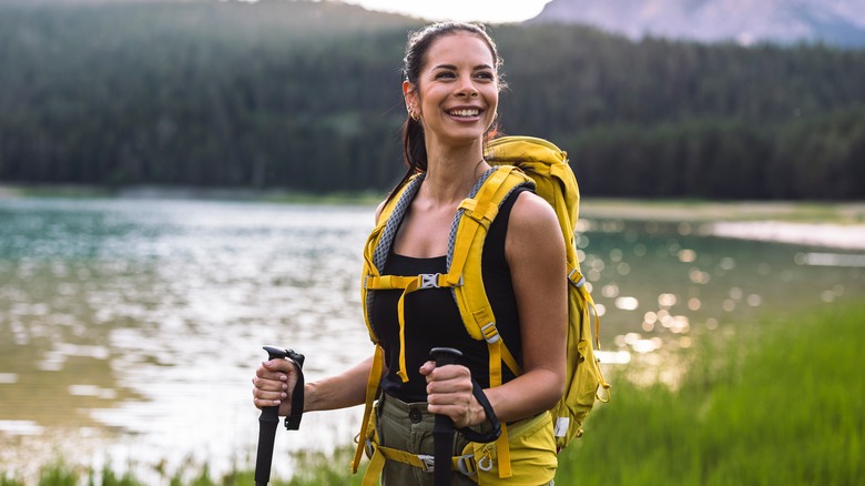 Smiling hiker standing near water