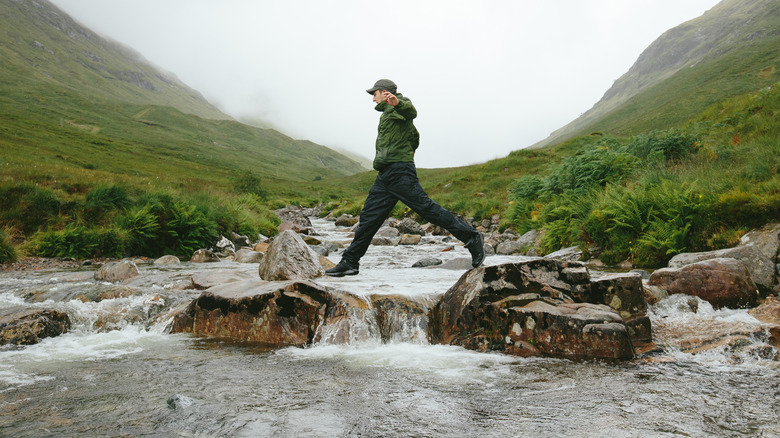 Man crossing water during hike